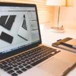 Modern workspace featuring a laptop, digital pen, and pad for creative work.